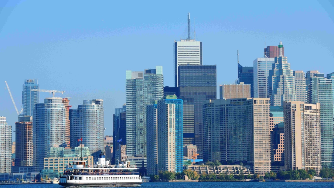 Toronto skyline in the day over lake with urban architecture.